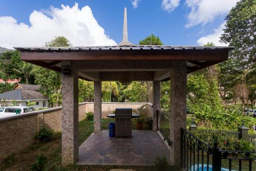 a pergola with a trash can in a yard at Beau Vallon Villa Chalets in Beau Vallon