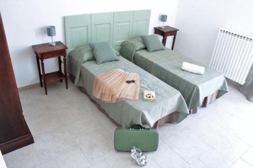 una camera con due letti e una valigia sul pavimento di A casa ventotto a Mesagne