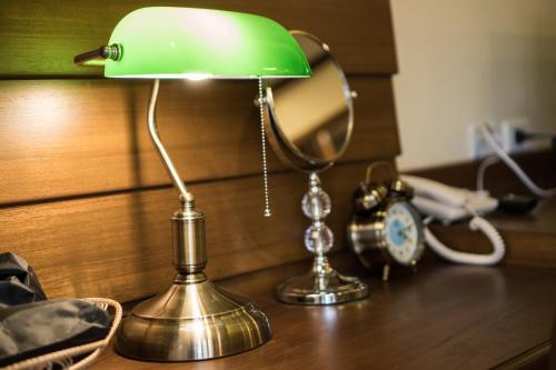 a green lamp sitting on a table next to an alarm clock at Wannamas Chiangmai Boutique House in Chiang Mai