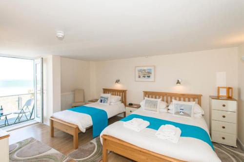 two beds in a room with a window at The Penellen guest accommodation room only in Hayle
