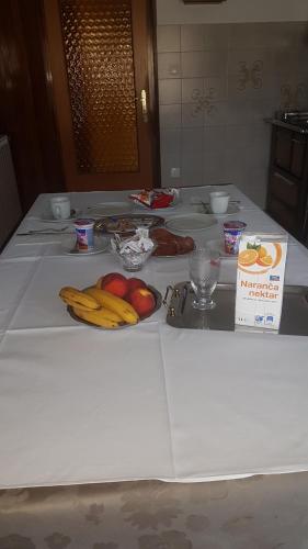 a table with bananas and apples on top of it at Guest House Mrvčić in Rupa