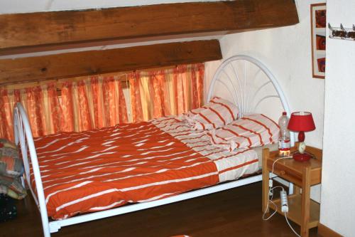 グリュイッサンにあるPALMIER SOLEIL 410のベッド1台(オレンジと白の掛け布団付)