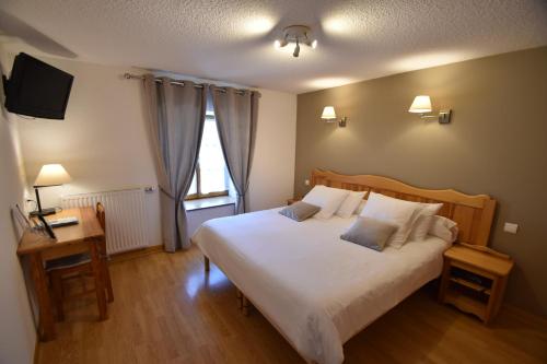 Dormitorio con cama, escritorio y TV en Domaine de la Plagnette en Les Salles
