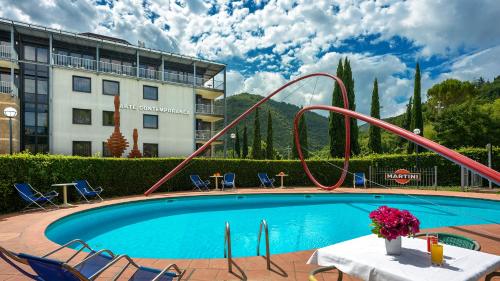 uma piscina com escorrega em frente a um hotel em Albornoz Palace Hotel em Spoleto