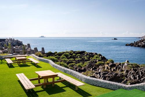 a group of benches sitting on the grass near the water at Brighthouse in Suao