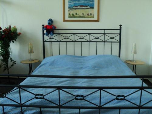 Un dormitorio con una cama negra con un osito de peluche. en Villa Germania Südbalkon, en Ahlbeck