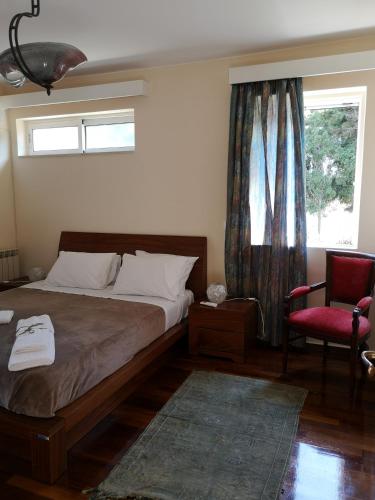 a bedroom with a bed and a chair and a window at Villa Leonidas in Mastichari