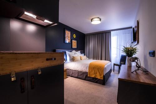 a hotel room with a bed and a desk at Best Western Plus Suitcase Paris La Défense in Bois-Colombes