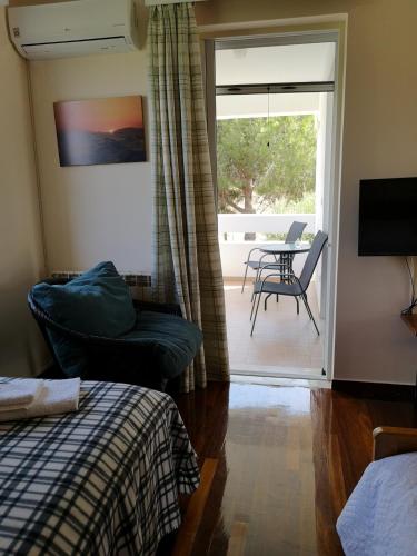 a room with a bed and a patio with a table at Villa Leonidas in Mastichari