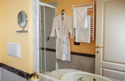 ein Bad mit einem Bademantel, der in der Dusche hängt in der Unterkunft Hotel Pushkin in Oral