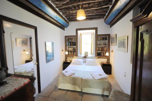 a bedroom with a bed and a mirror at Rallou House Hydra in Hydra