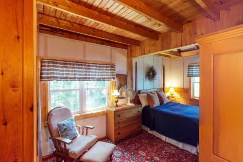 ein Schlafzimmer mit einem Bett, einem Stuhl und einem Fenster in der Unterkunft Pebble Cove in The Highlands