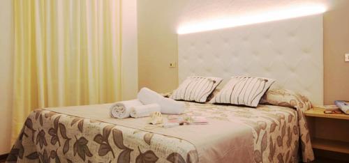 a hotel room with a bed with towels on it at Hotel Sandra in Rimini