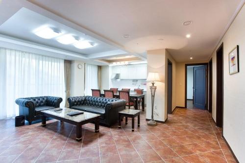 a living room with couches and a table and chairs at Jeongseon Mayhills Resort in Jeongseon