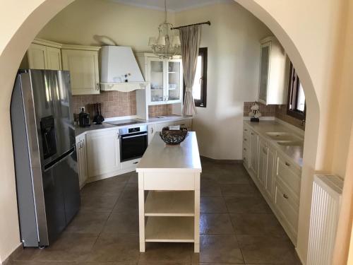 a kitchen with white cabinets and a white counter top at M Varkes Villa in Nea Moudania