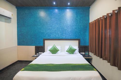 a bedroom with a large bed with a blue wall at Yashogopal Resortico in Vrindāvan