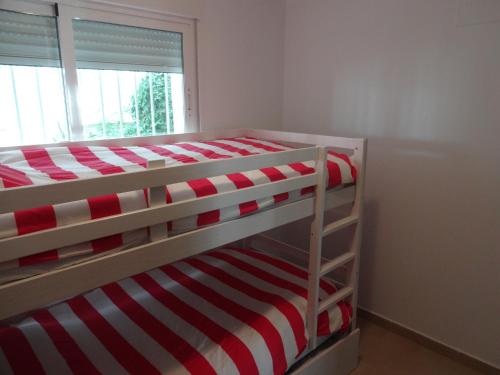 Dormitorio con litera de rayas rojas y blancas en Linnea Sol Blanca, en Villamartin