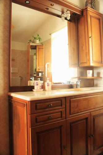 a bathroom with a sink and a large mirror at mansarda fiorita in Abatemarco