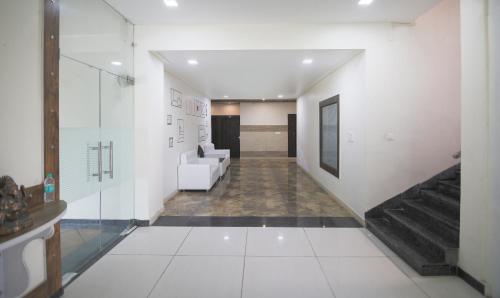 a hallway with a living room with white furniture at Yashogopal Resortico in Vrindāvan