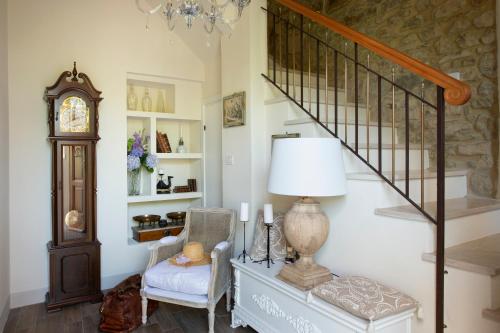a living room with a staircase and a chair and a lamp at La Casetta di Brunello in Montalcino