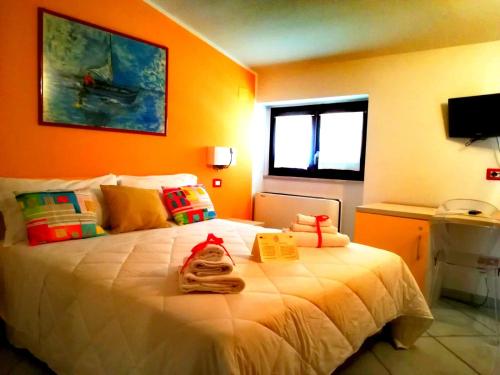 a bedroom with a large white bed with orange walls at Victoria Resort in Ascea