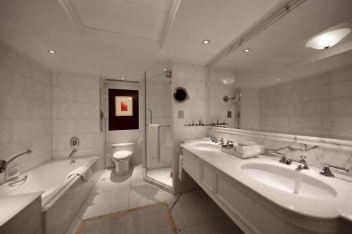 澳門的住宿－皇都酒店，一间带两个盥洗盆、浴缸和卫生间的浴室