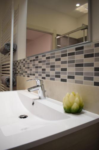 a bathroom sink with a bowl of fruit on it at Appartamento Oleandro in Arco