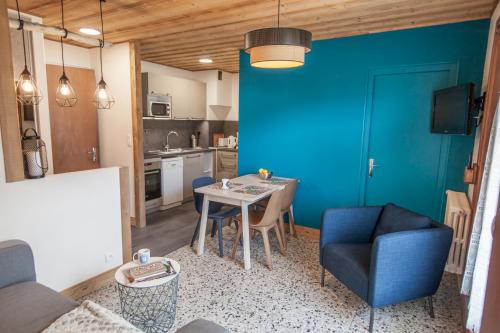a living room with a table and a blue wall at Appartements Giffre et Clesson - DAHU COMPAGNIE in Samoëns