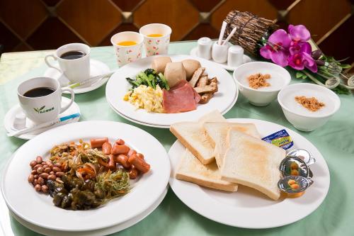 a table with plates of food and cups of coffee at European Castle歐堡商務汽車旅館有限公司 in Xinying