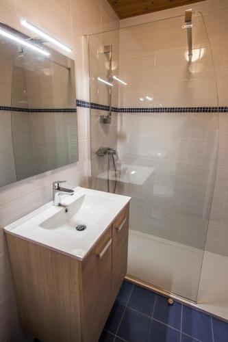 a white bathroom with a sink and a shower at Appartements Giffre et Clesson - DAHU COMPAGNIE in Samoëns