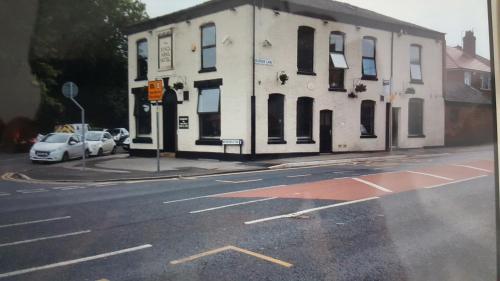 a building on the corner of a street with a car at Kings arms hotel in Farnworth