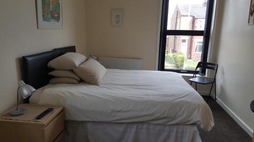 a bedroom with a bed with white sheets and a window at Kings arms hotel in Farnworth