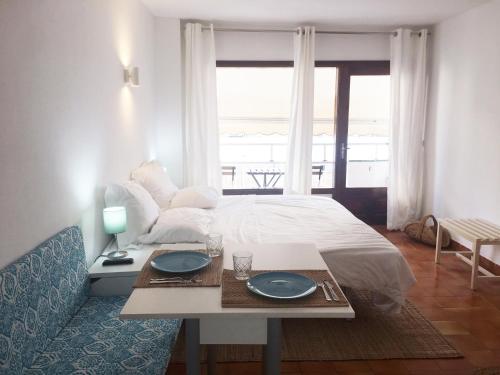 ein Schlafzimmer mit einem Bett und einem Tisch mit Tellern darauf in der Unterkunft Apartamentos Albertos in Santa Eulària des Riu