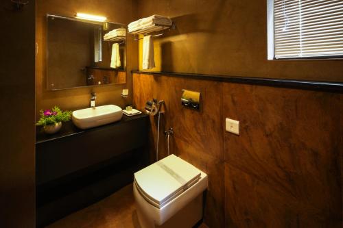 a bathroom with a toilet and a sink and a mirror at The Serenity Resort in Tariyod