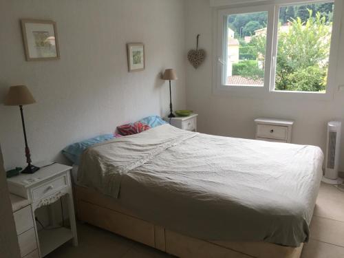 um quarto com uma cama branca e uma janela em Fleur de mai em Roquebrune-Cap-Martin