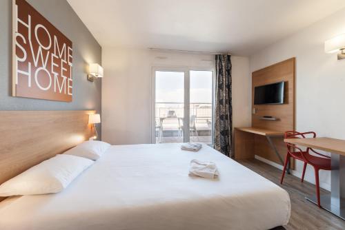 a hotel room with a large bed and a balcony at Residhotel Le Grand Prado in Marseille