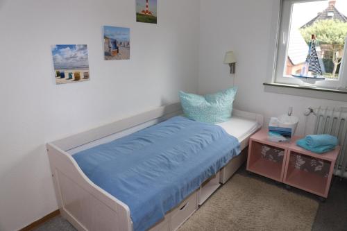 a bed in a room with a window at Ferienunterkunft auf Sylt in Westerland (Sylt)
