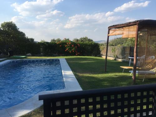 un patio trasero con piscina y cenador en Casa Rural Lago Bolarque, en Albalate de Zorita