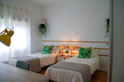 2 camas con almohadas verdes en una habitación en Real Beds Madrid, en Madrid