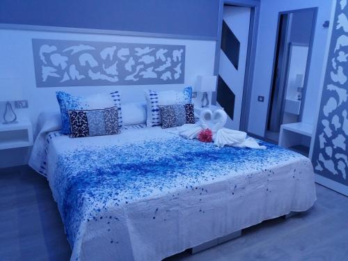 a bedroom with a large bed with blue and white pillows at Hotel Drago San Antonio in Icod de los Vinos