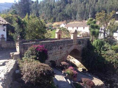 a stone bridge over a river in a village at La Estancia de la Pradera Cabana Fiba in Nobsa