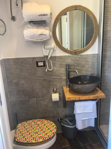 a bathroom with a sink and a toilet and a mirror at Case Vacanza Calamaro in Trabia