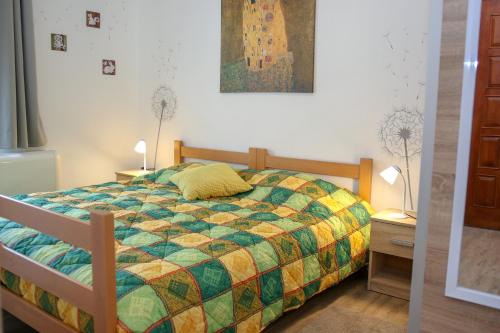 a bedroom with a bed with a colorful quilt at Apartment Polic in Šibenik