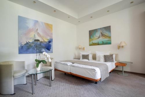 a bedroom with a bed and a couch and a table at Aparthotel Villa Freisleben in Dresden