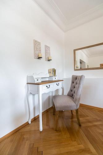 a white desk with a chair and a mirror at Aparthotel Villa Freisleben in Dresden
