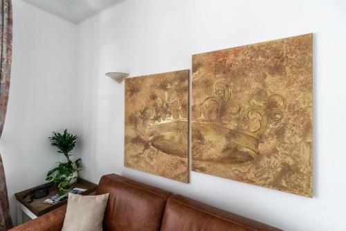 three pieces of art on a wall next to a couch at Aparthotel Villa Freisleben in Dresden