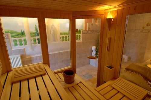 Habitación de madera con ducha y banco en Hotel Die Tanne, en Goslar