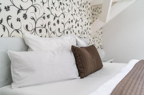 a white bed with white pillows and a black and white wall at Aparthotel Villa Freisleben in Dresden