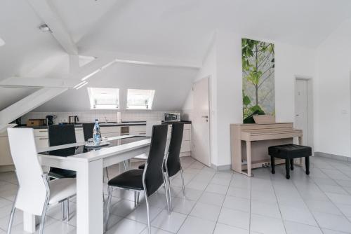 a white kitchen with a dining table and chairs at Aparthotel Villa Freisleben in Dresden
