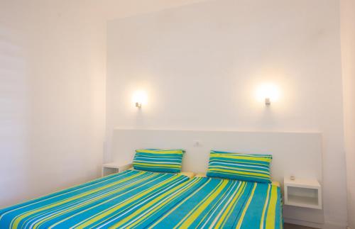 プラヤ・デル・イングレスにあるSunny Villageのベッドルーム1室(青と黄色のストライプの枕2つ付)